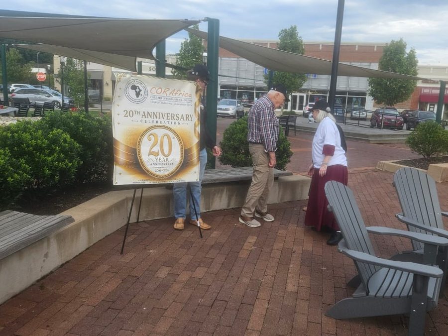 Guests walking past the anniversary banner in an open-air plaza