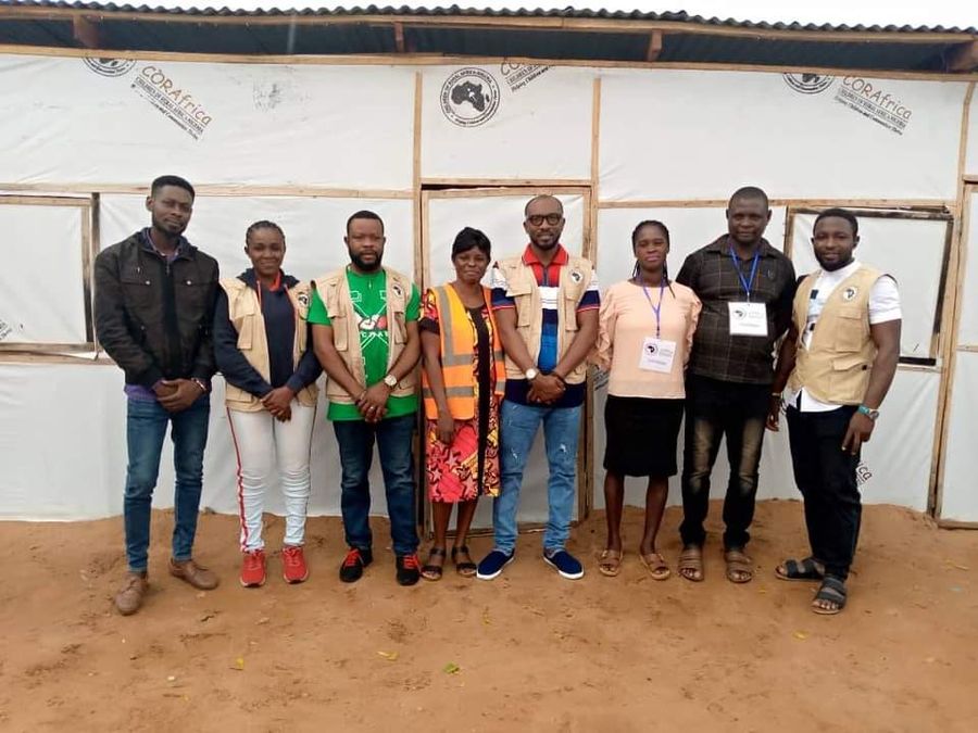 CORAfrica field staff outside a shelter at a settlement