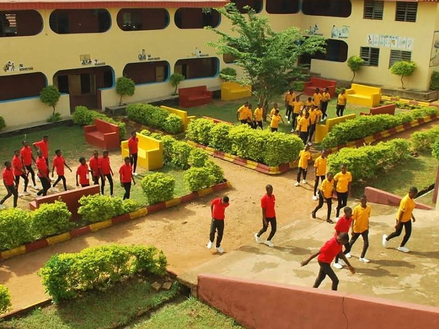 Pupils in red and yellow house colours crossing the courtyard at St. Joseph&rsquo;s