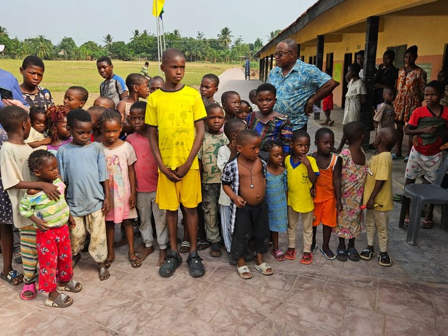 Children gathered on the stamped walkway outside the classrooms of the Victoria Schools